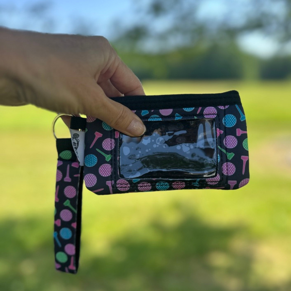 Golf-themed credit card wristlet holder with ID window and hand strap, perfect for golfers and light travel.